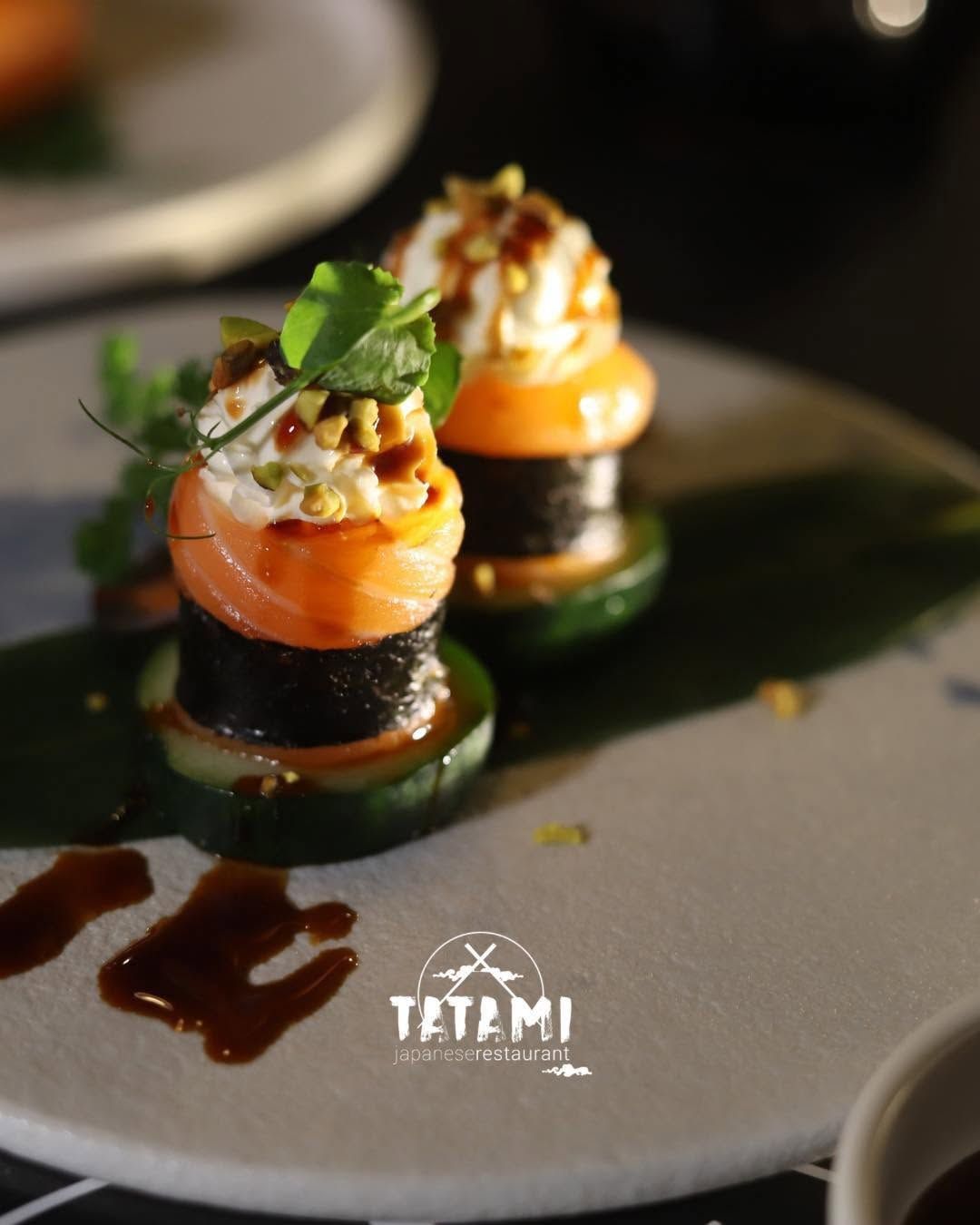 Canapè gourmet al salmone con erbe aromatiche su un piatto scuro, guarniti con salsa
