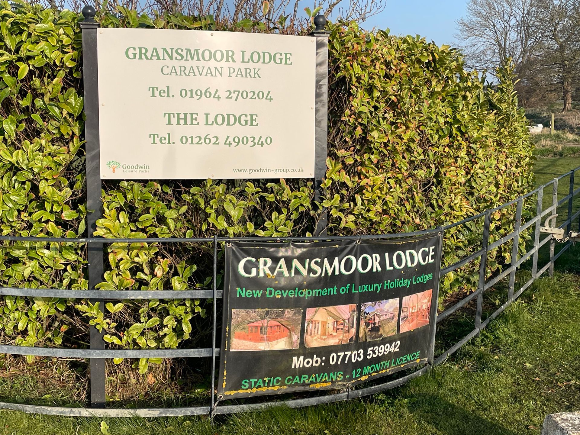 Sign for Gransmoor Lodge Caravan Park with phone numbers; banner for static caravans.