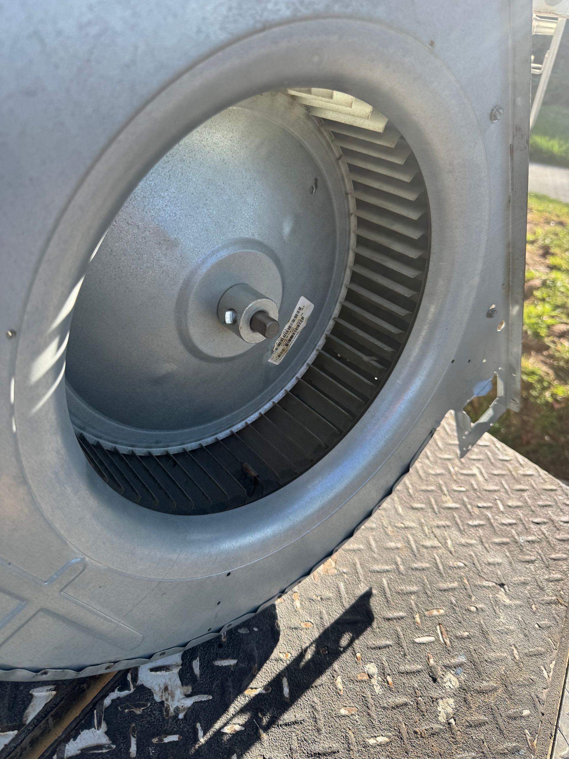 Close-up of a large industrial fan inside a gray metal housing.
