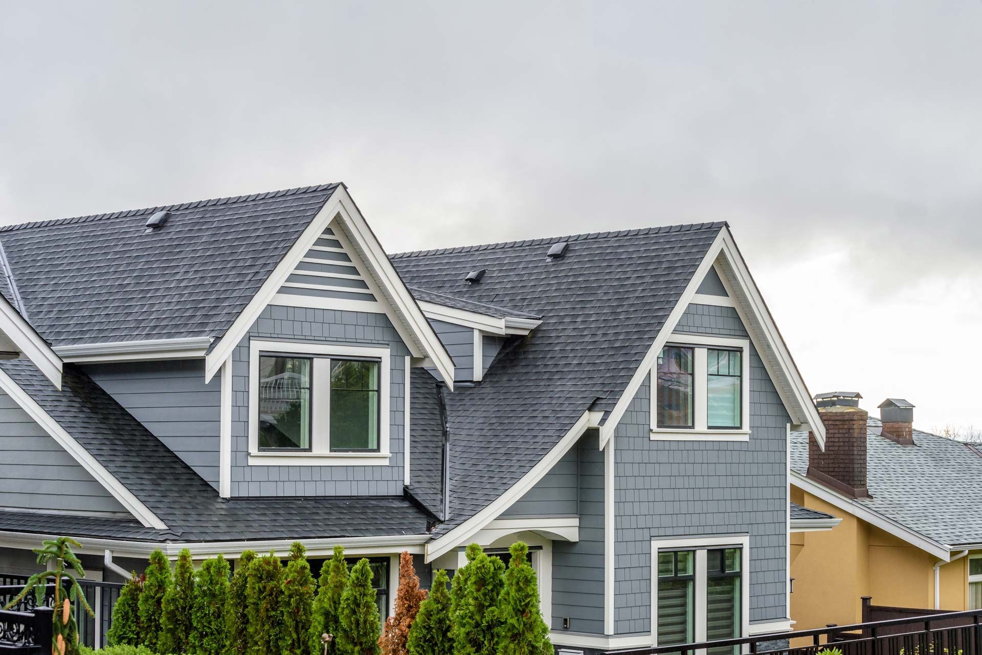 A row of houses with a gray roof on a cloudy day