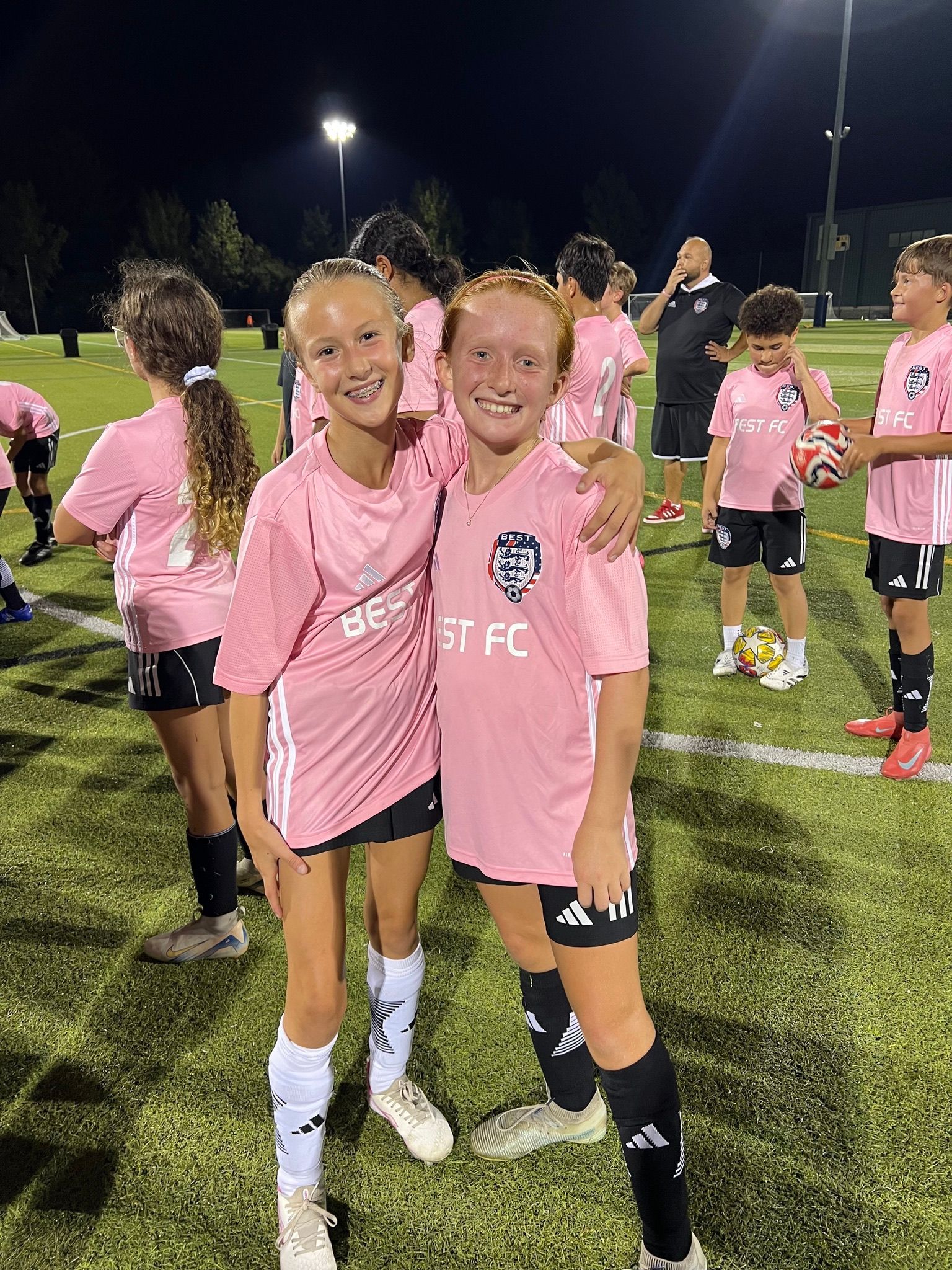 Two BEST FC soccer players in pink jerseys