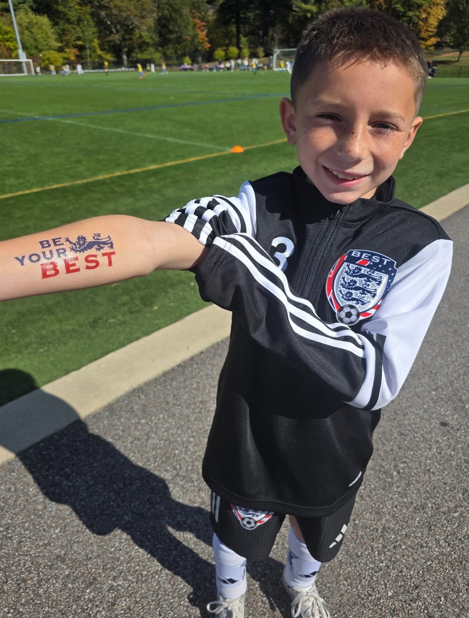 BEST FC  soccer player on a field showing a “Be Your Own Best” arm tattoo