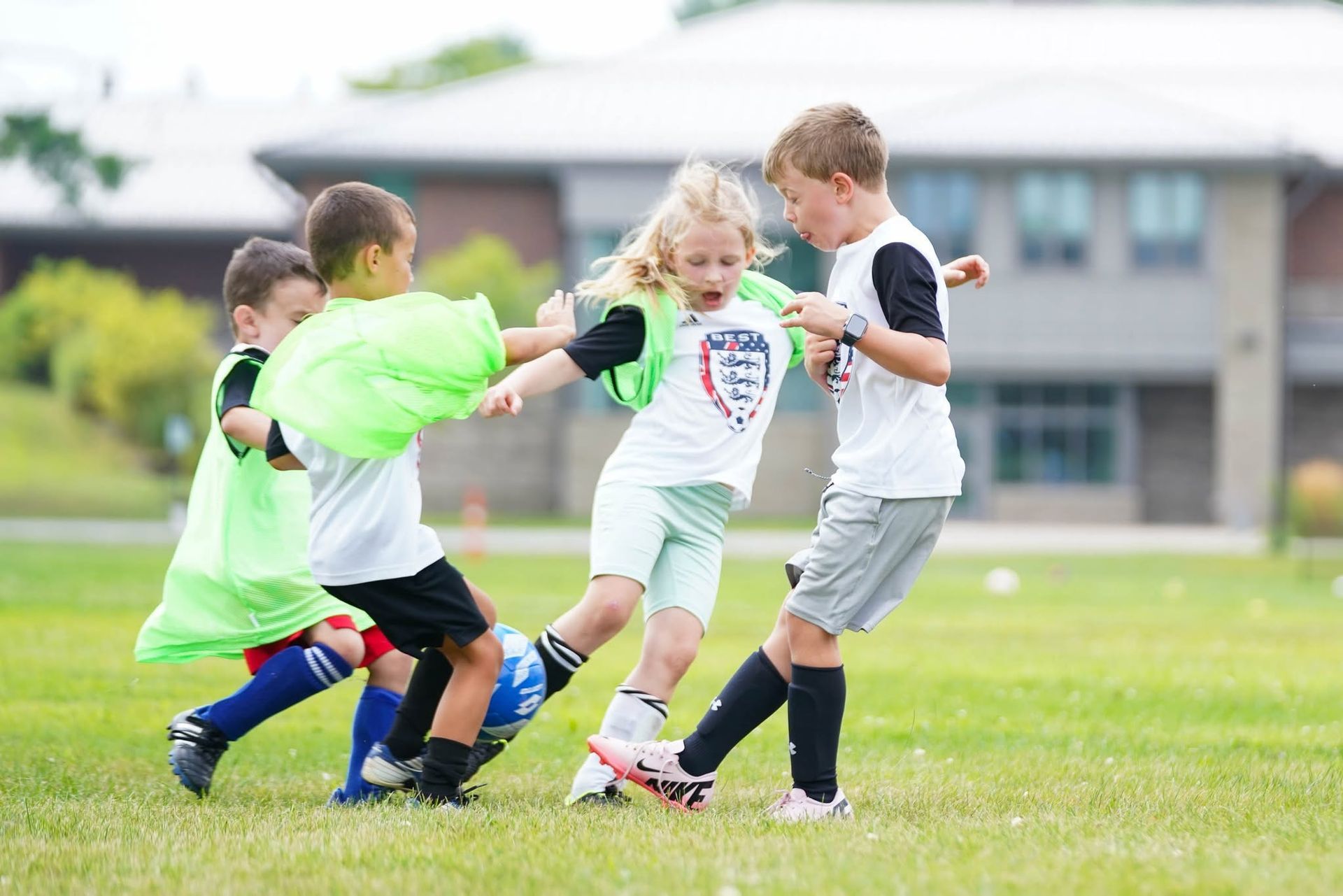 BEST FC girls and boys playing soccer on a field