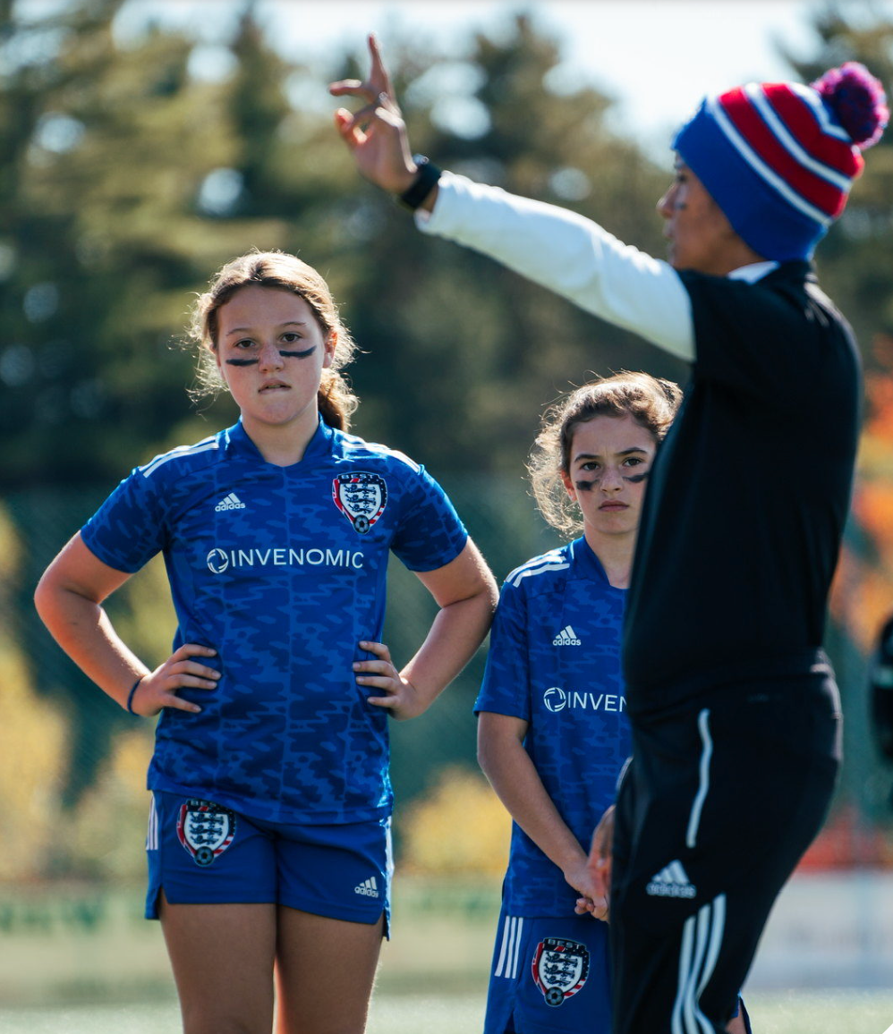 Soccer coach giving instructions to BEST FC players