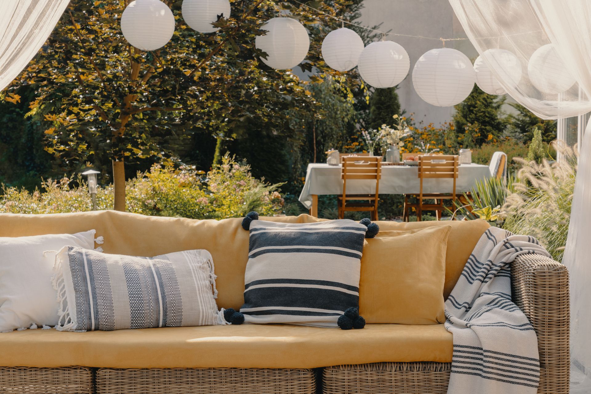 Stylish and custom outdoor cushions and pillows on a couch in a backyard space