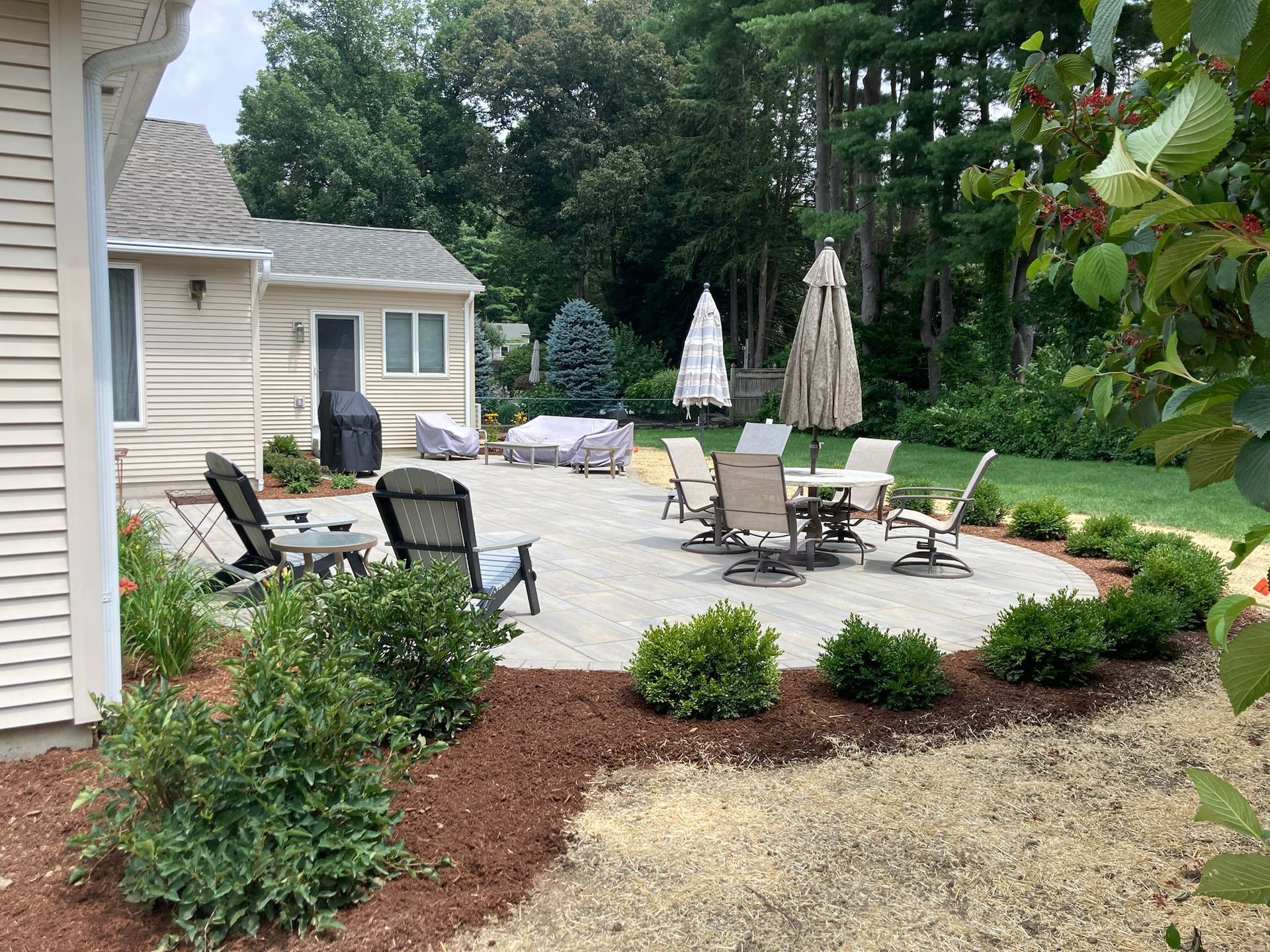 Custom paver patio installation with outdoor living space and landscaping at a Western Massachusetts home