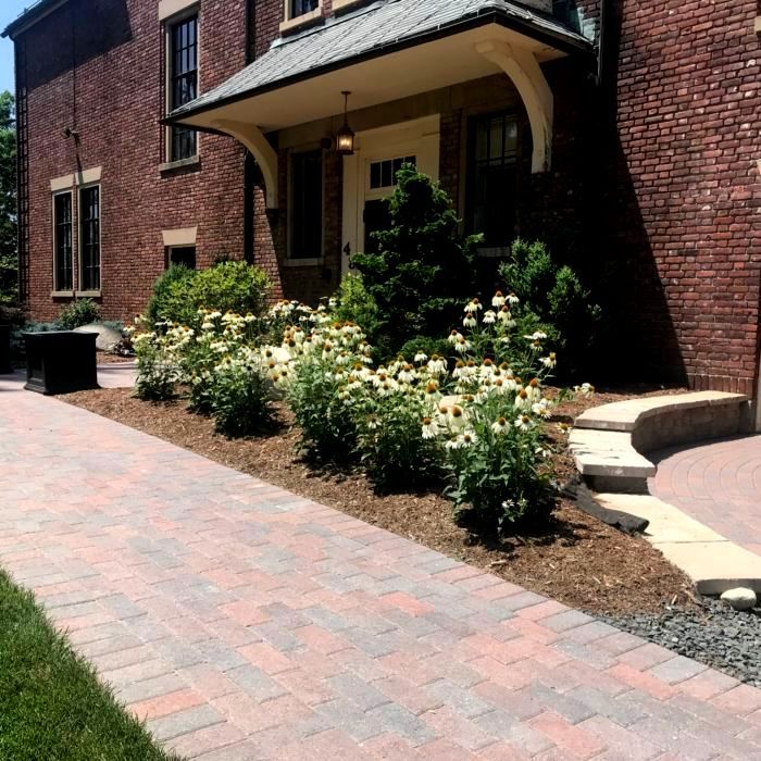 Custom landscape design with brick walkway and curated garden beds at a Western Massachusetts home