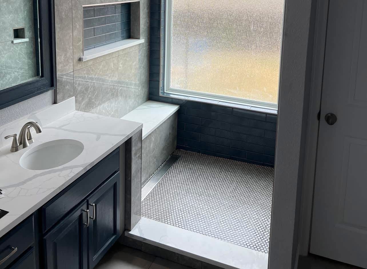 Modern bathroom with vanity, sink, tub, and glass-enclosed shower area