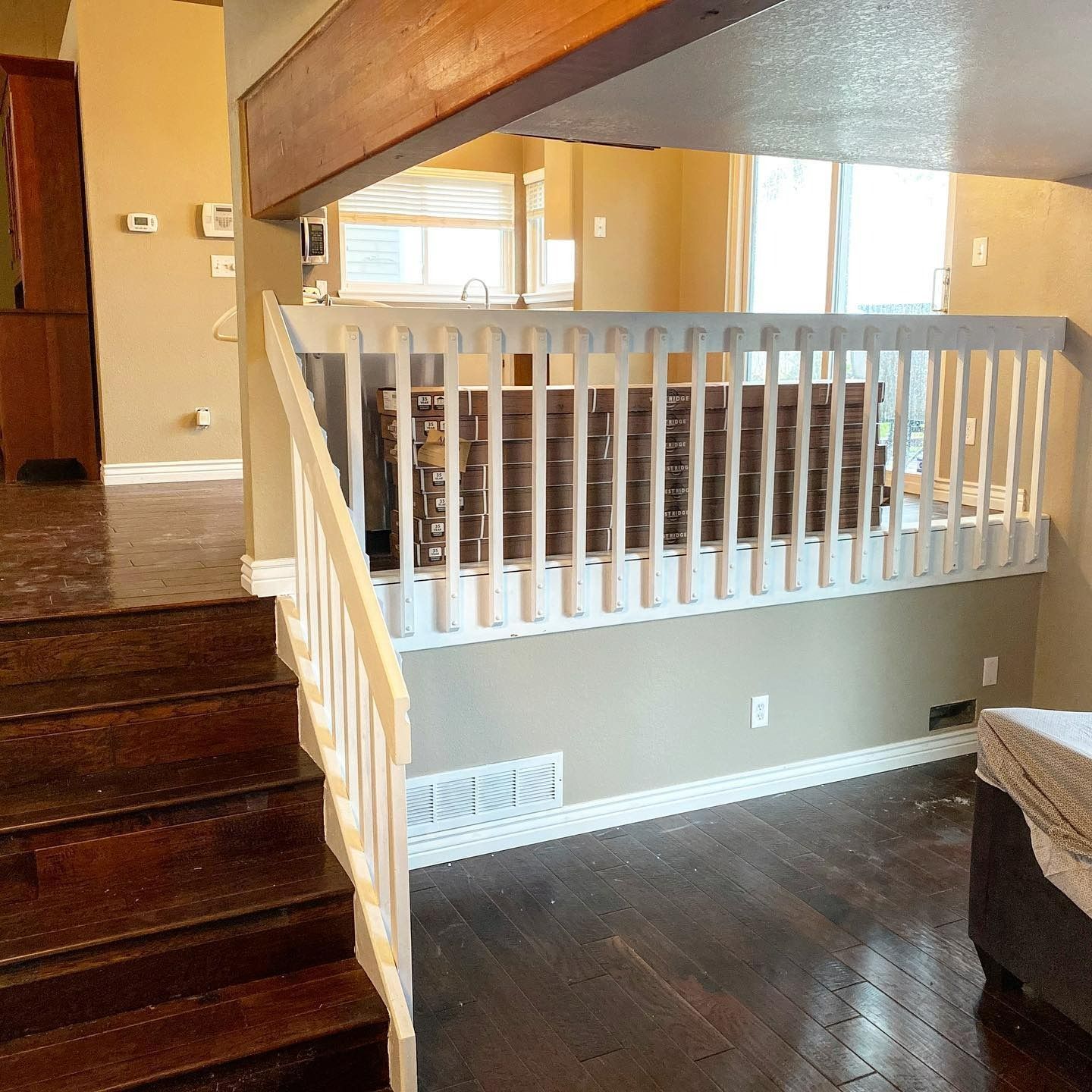 Interior view of a home with a staircase, white railing, and hardwood floors leading to a loft area