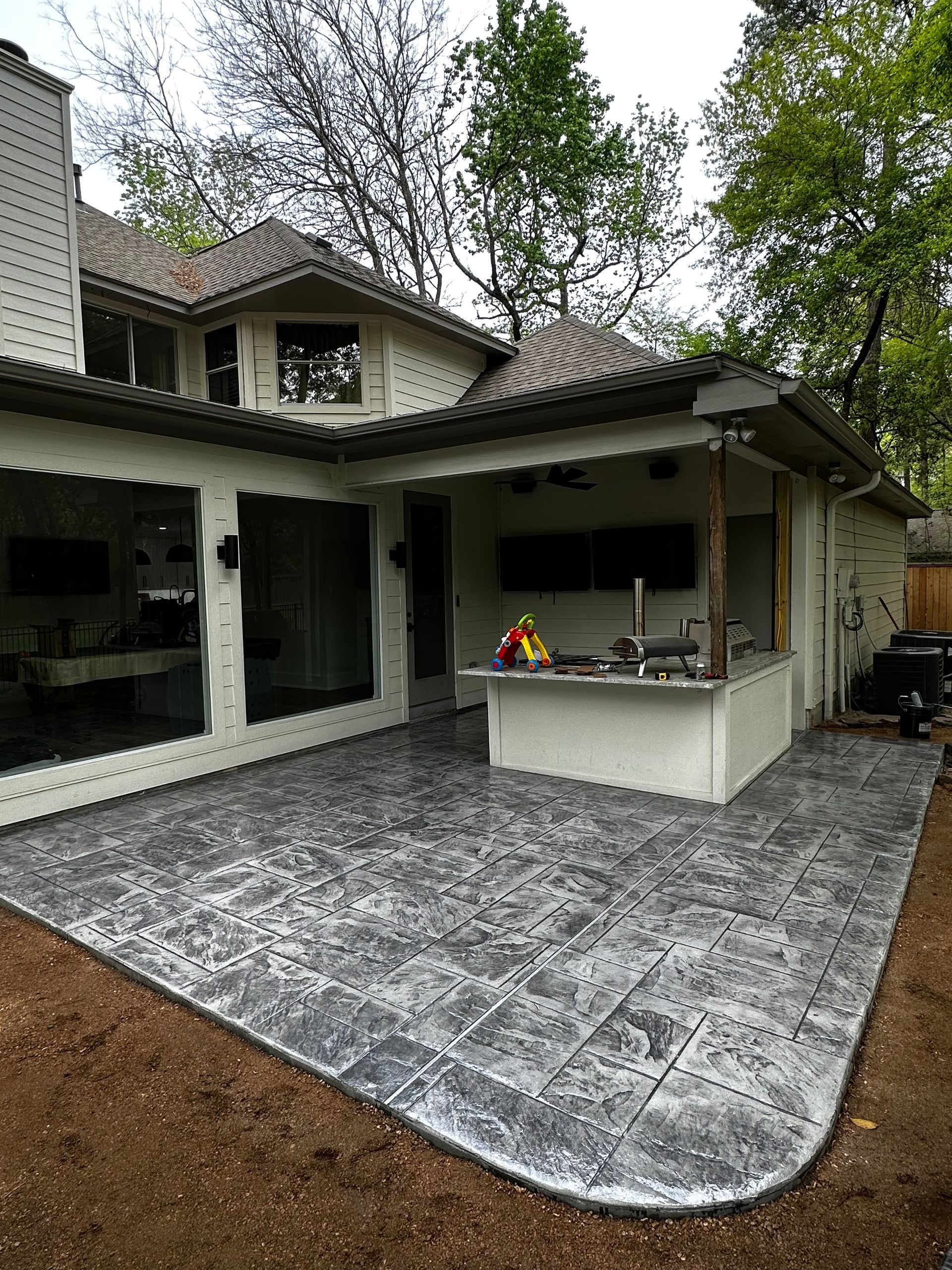 A large house with a patio and a kitchen in the backyard.