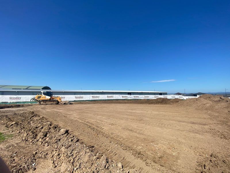 A large pile of dirt is sitting in front of a large building.