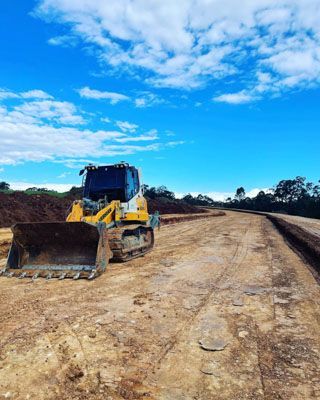 A bulldozer is sitting on top of a dirt road.