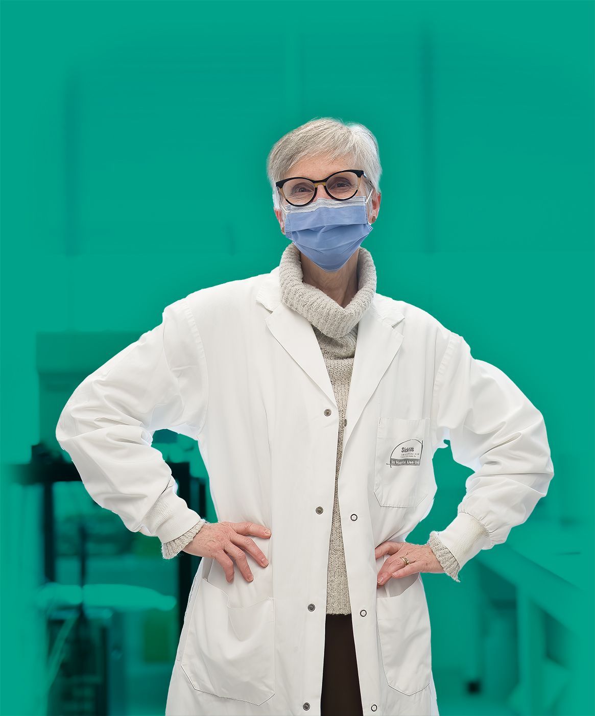 A female CF researcher at Sick Kids hospital stands with her hands on her hips.