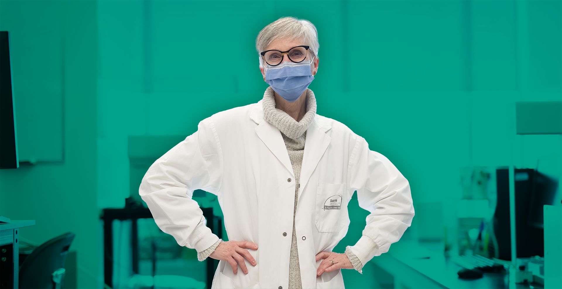 A female CF researcher at Sick Kids hospital stands with her hands on her hips.
