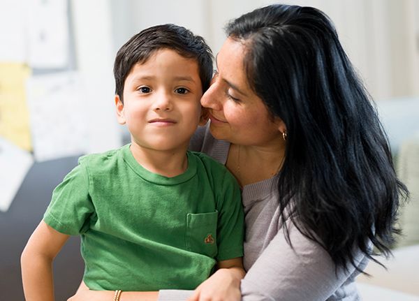 Vicki and her son Sebastien cuddle on the couch.