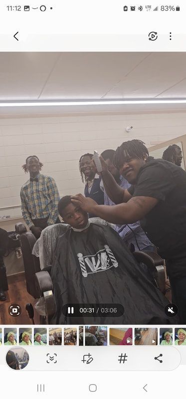 A group of people are getting their hair cut at a barber shop.