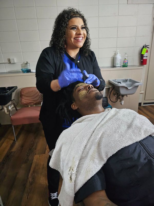 A woman is washing a man 's hair in a salon.