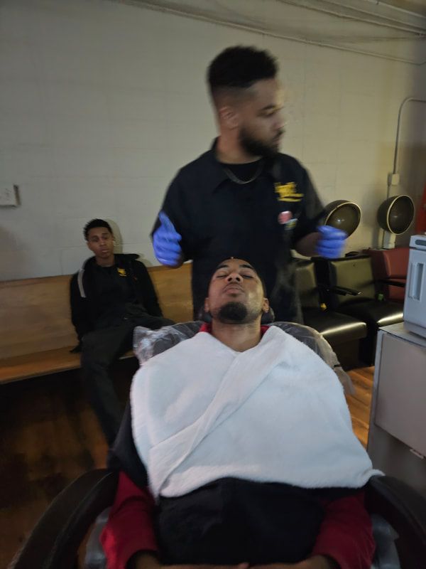 A man is getting his hair cut at a barber shop