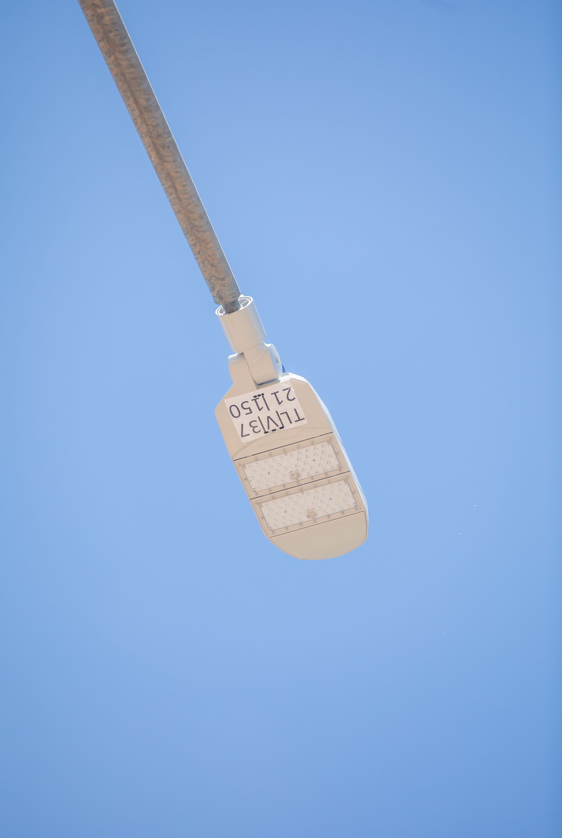 A beige retractable keychain with a metal clip hangs against a blue background.