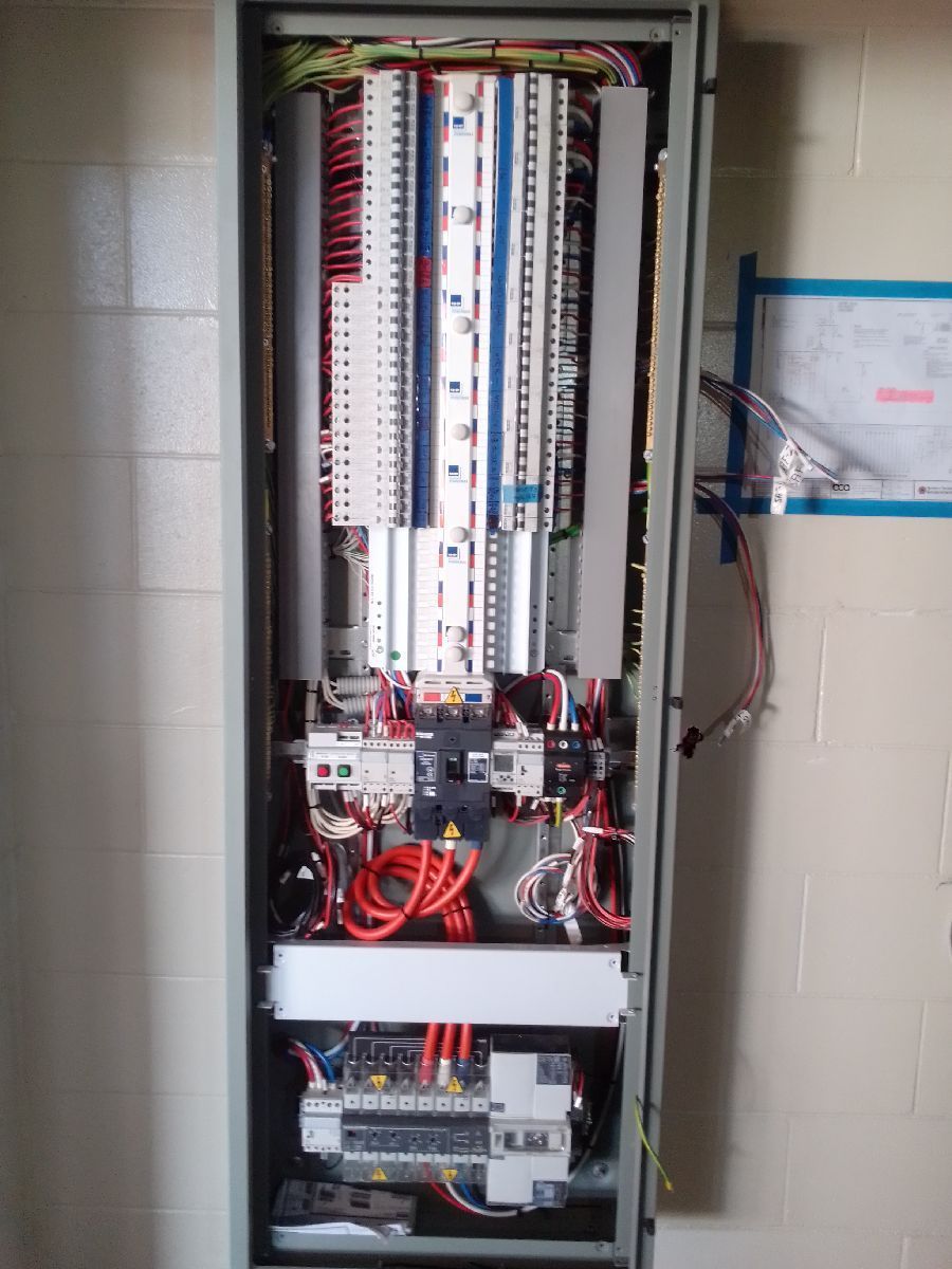 Open electrical control panel with wiring, terminal blocks, and circuit components.