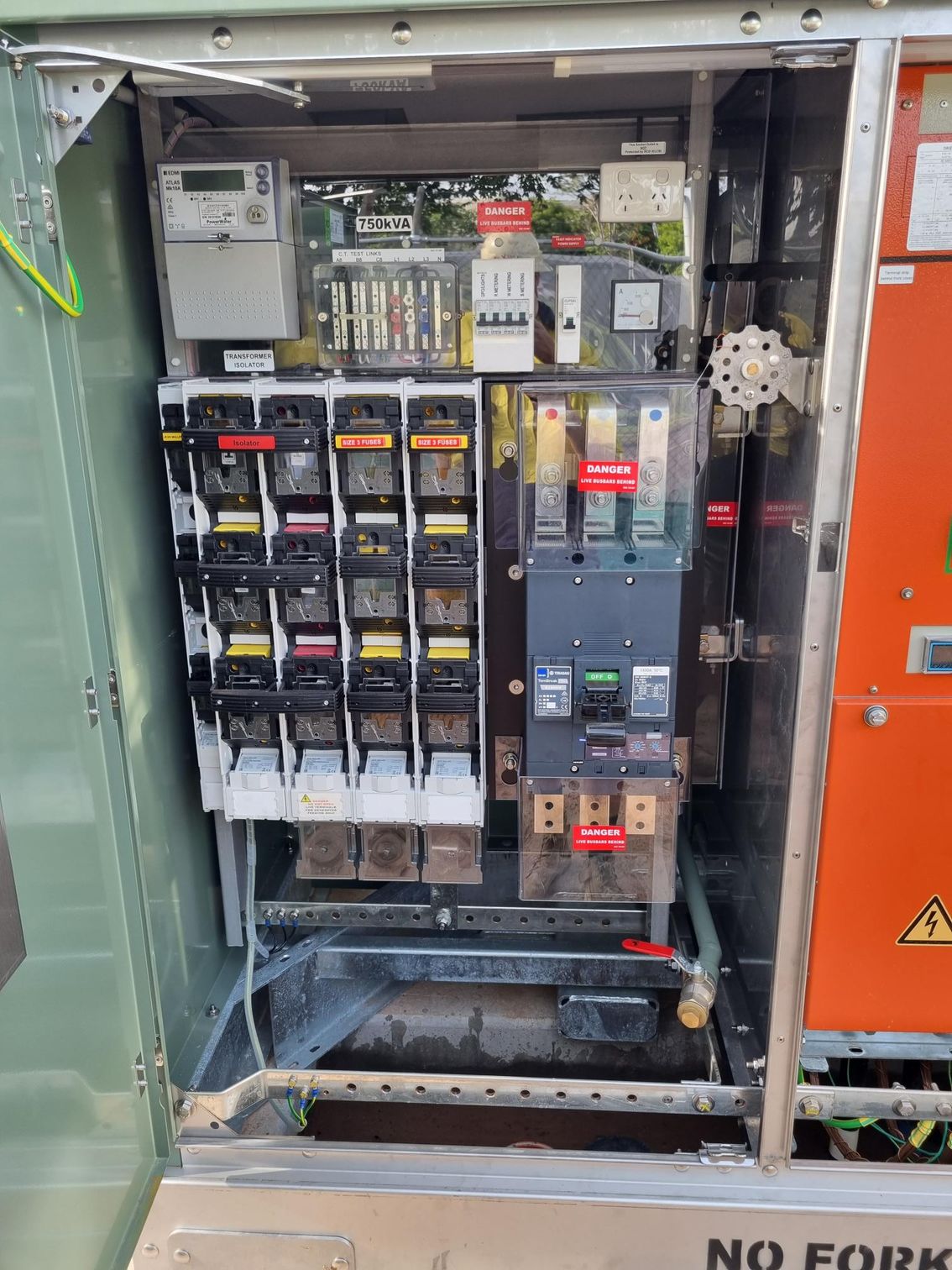 Open electrical control panel with breakers, relays, and wiring in a metal cabinet.