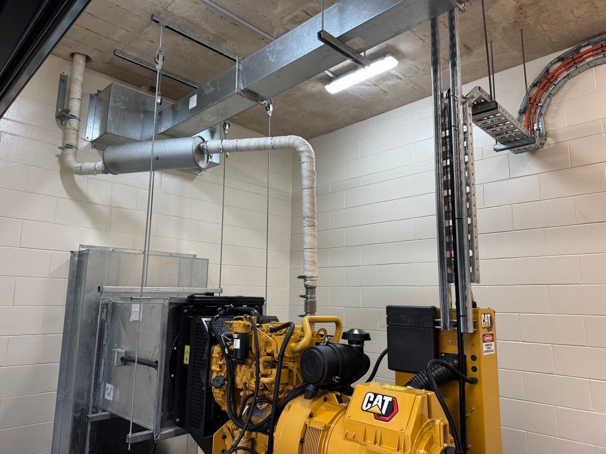 Industrial room with yellow machinery, metal ducting, and wall-mounted cabling in a tiled utility space