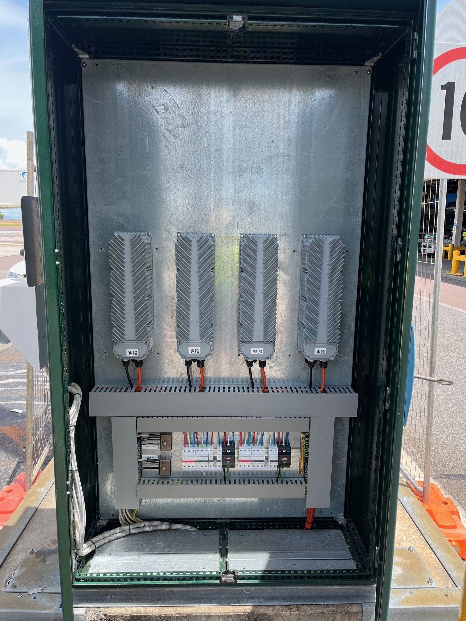 Electrical control cabinet with rows of gray components and wiring inside an open metal enclosure.