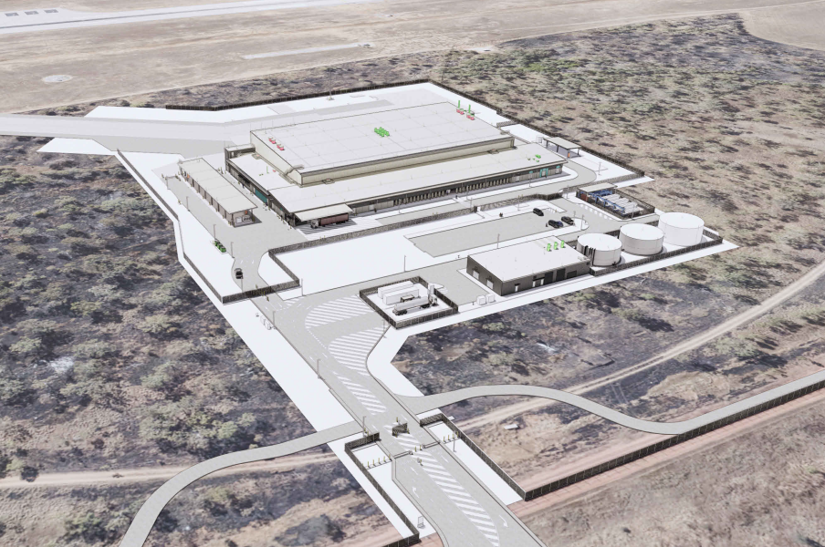 Aerial view of a large white building complex in a dry desert landscape.