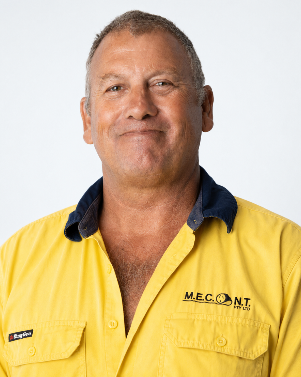 Portrait of a smiling worker in a yellow hi-vis shirt and navy collar against a white background