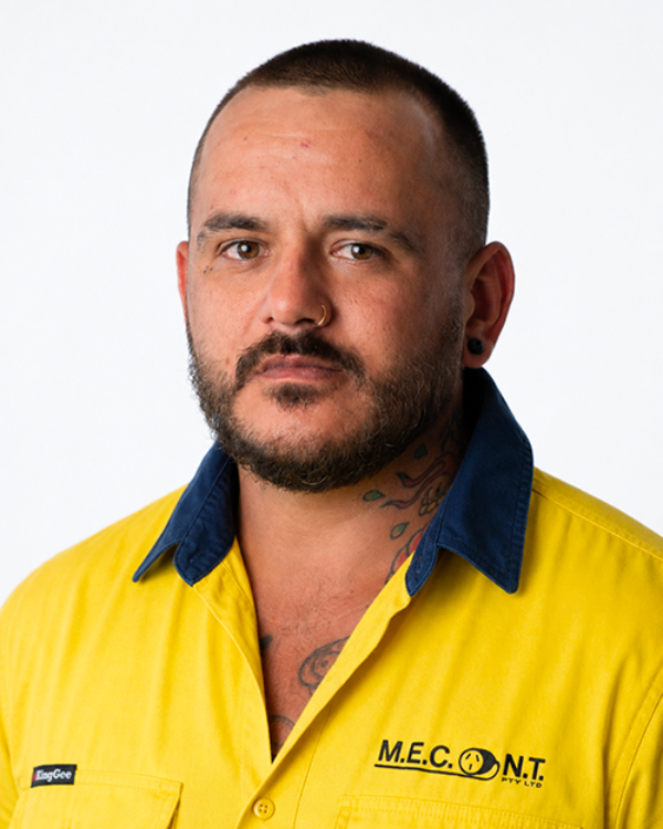 Man in a yellow collared work shirt with blue trim, facing forward against a white background