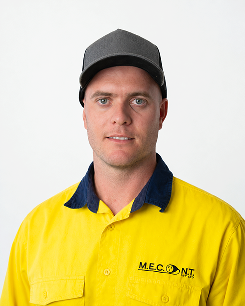Man in navy polo shirt smiling against a light gray background