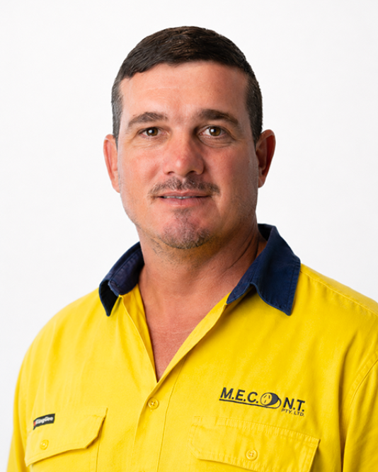 Man in navy polo shirt smiling against a light gray background