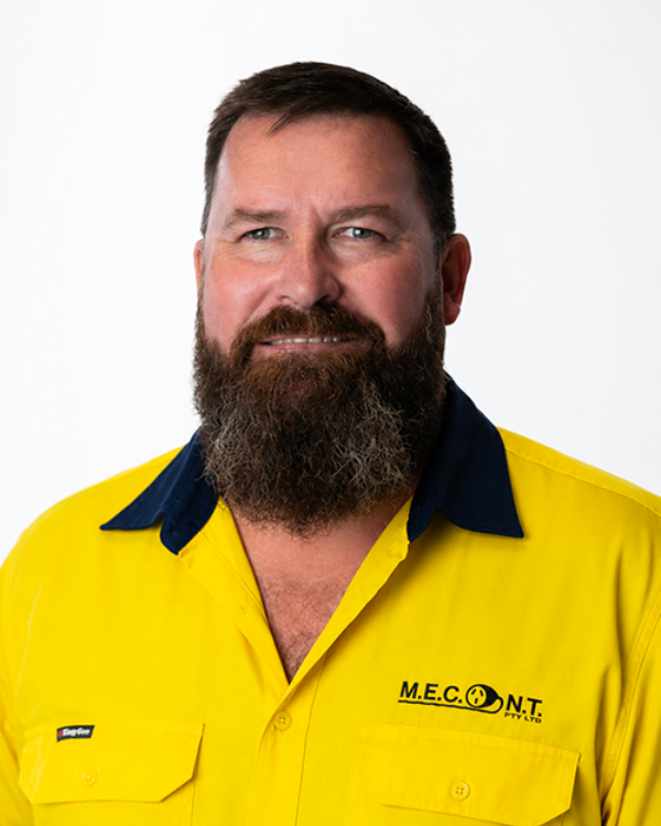 Man in navy polo shirt smiling against a light gray background