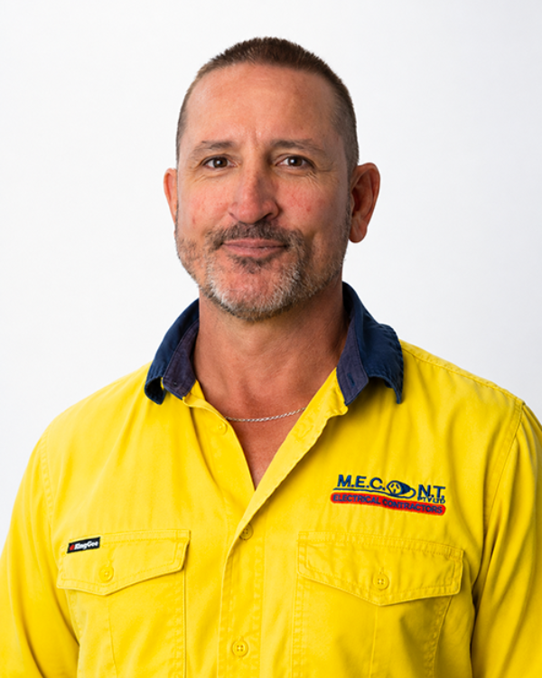 Man in navy polo shirt smiling against a light gray background