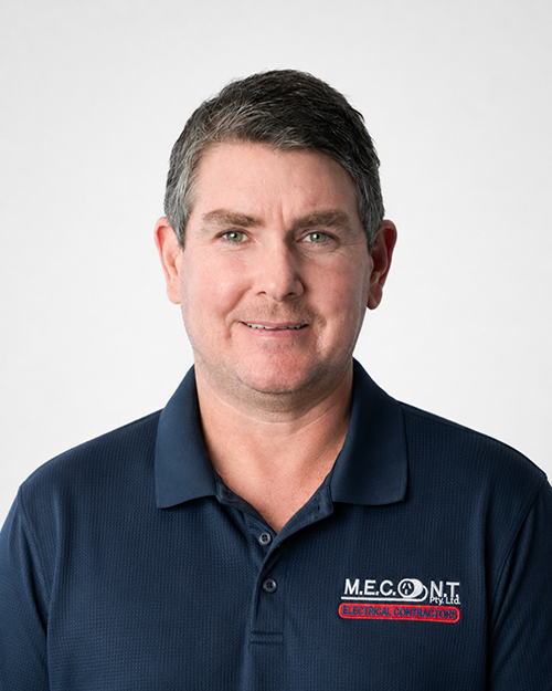 Man in navy polo shirt smiling against a light gray background