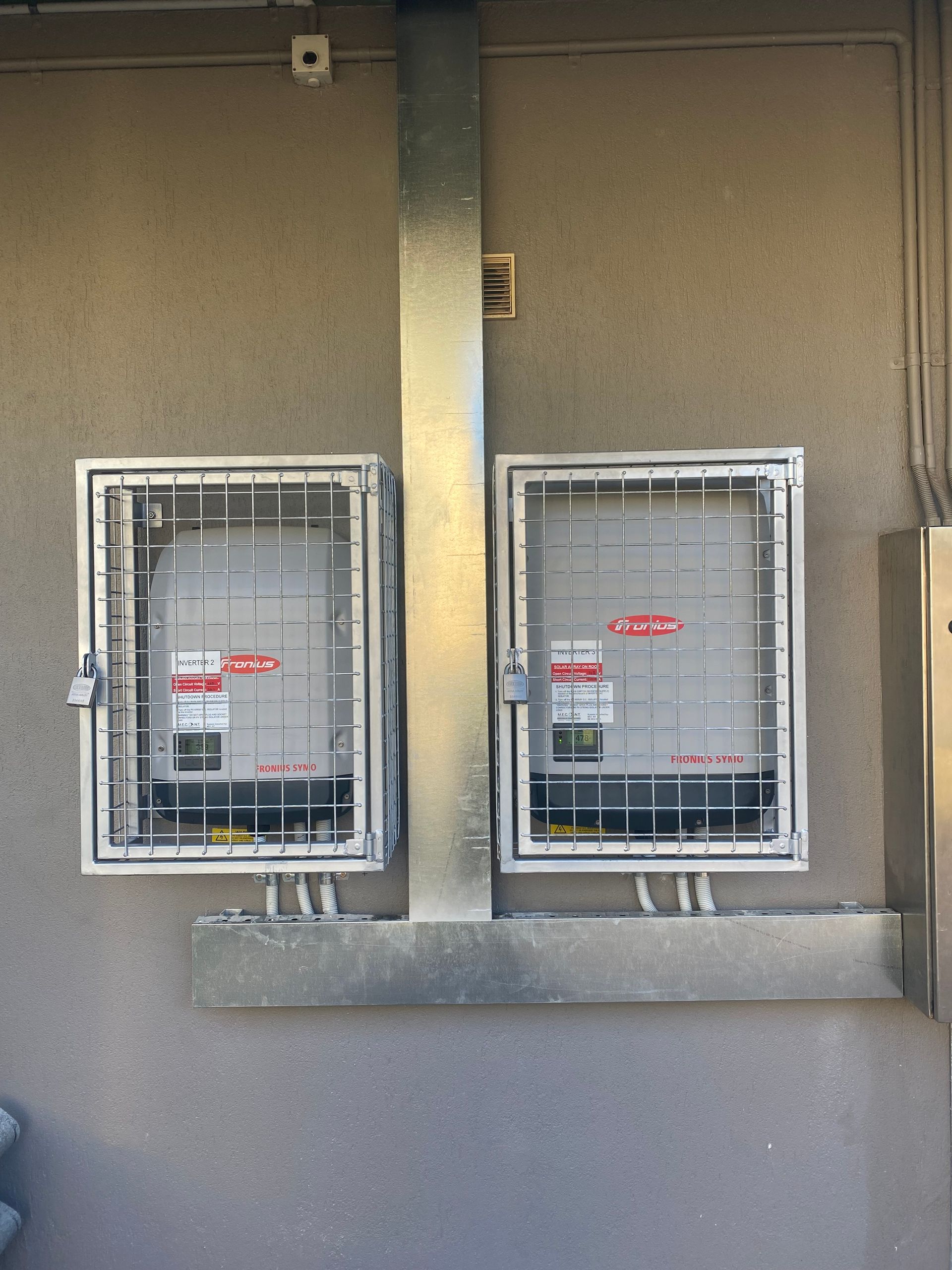Two covered utility meters mounted on a beige exterior wall