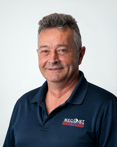 Man in navy polo shirt smiling against a light gray background