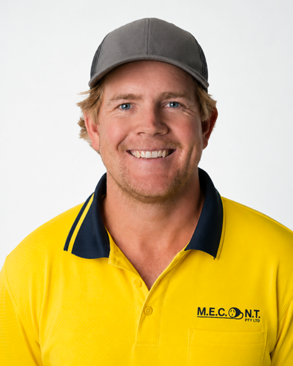 Man in navy polo shirt smiling against a light gray background