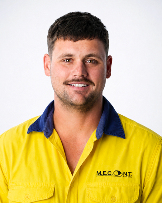 Man in navy polo shirt smiling against a light gray background