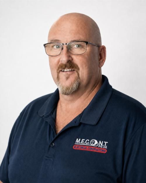 Bald man with glasses wearing a navy polo shirt with MECONT logo, posed against a white background