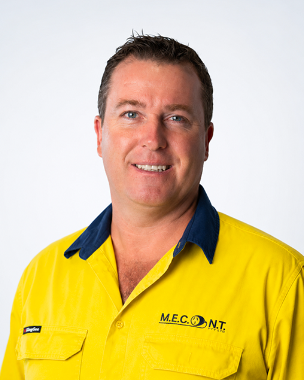 Man in navy polo shirt smiling against a light gray background