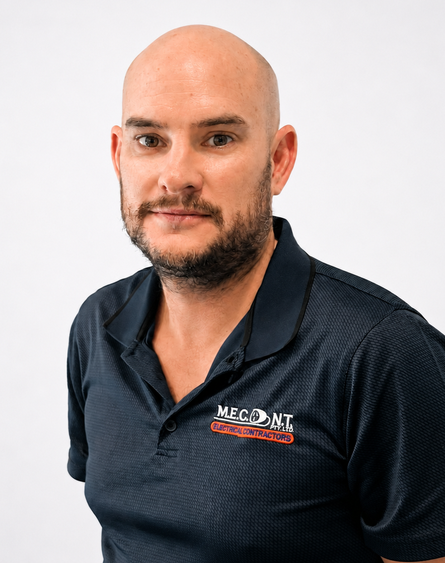 Man in navy polo shirt smiling against a light gray background