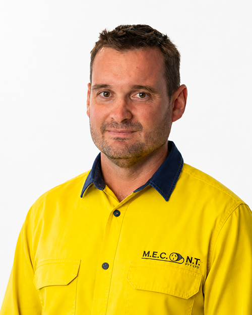 Man in navy polo shirt smiling against a light gray background