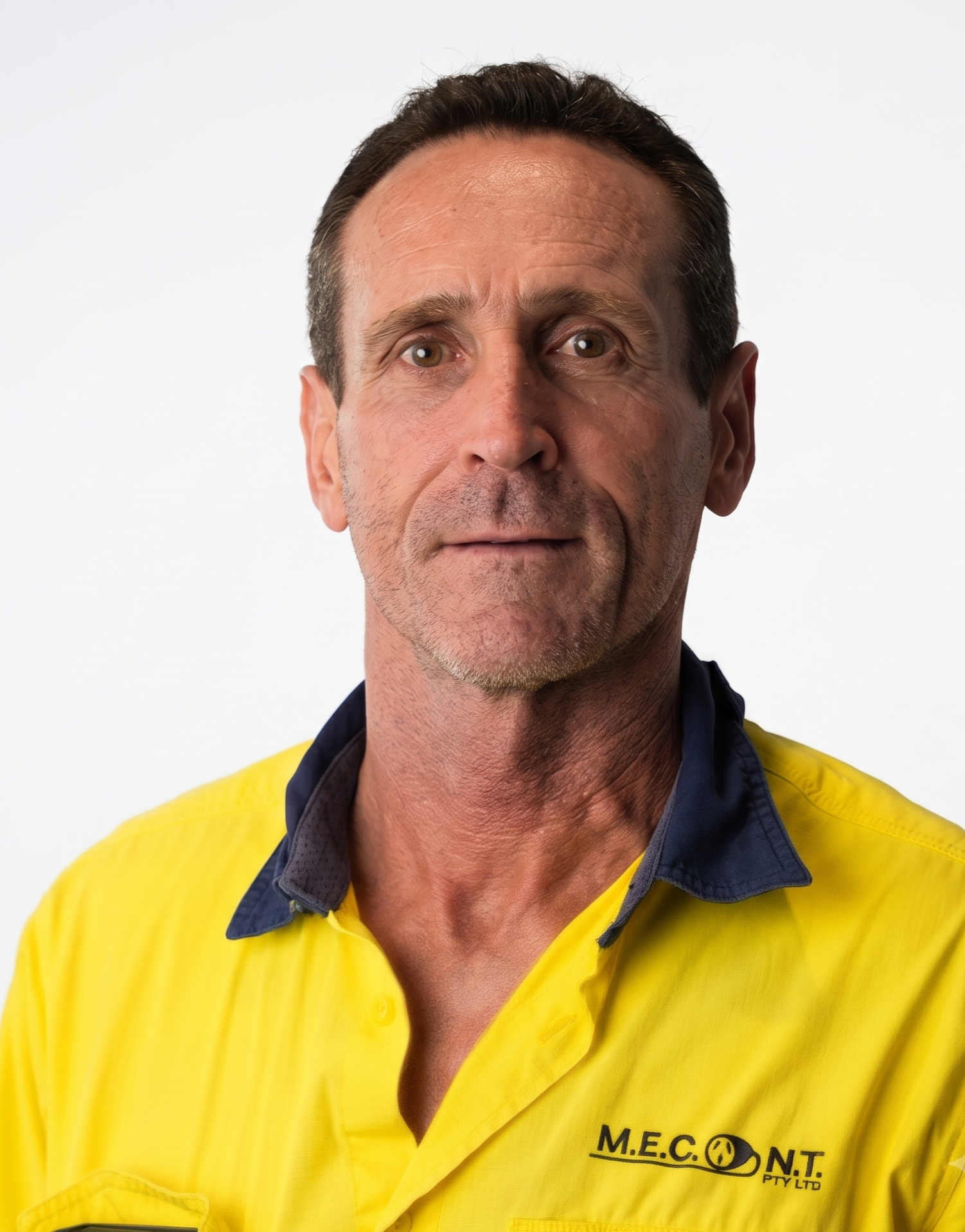 Portrait of a man in a bright yellow work shirt against a white background