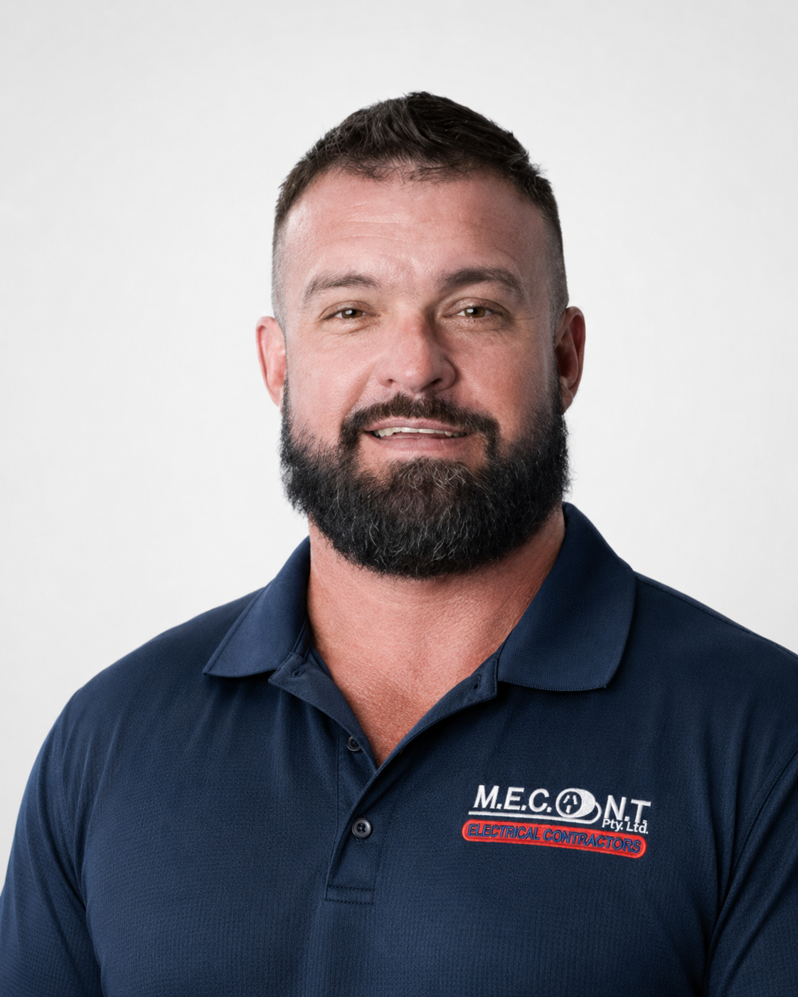 Man in navy polo shirt smiling against a light gray background