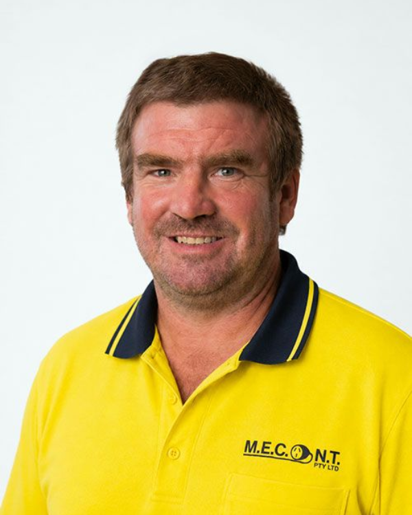 Man in navy polo shirt smiling against a light gray background