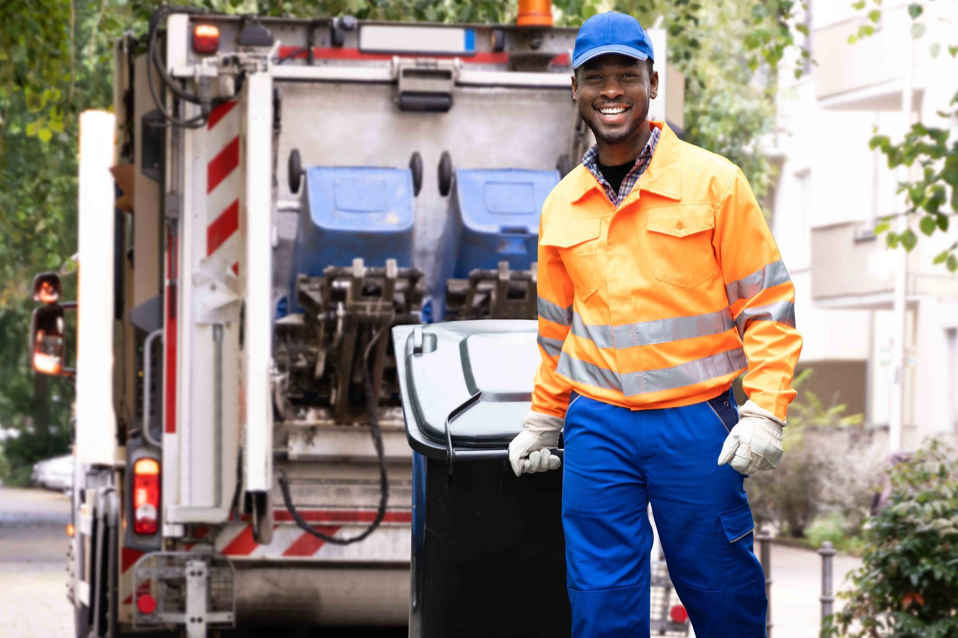 A worker rolling a trash bin toward a garbage truck during residential curbside pickup A worker rolling a trash bin toward a garbage truck during residential curbside pickup