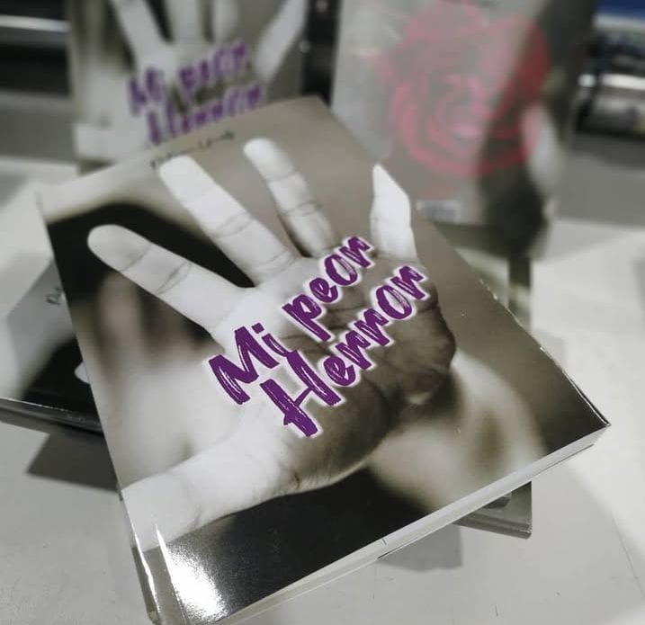 Pila de libros con diseño de huellas de manos y texto morado "Mi peor horror".
