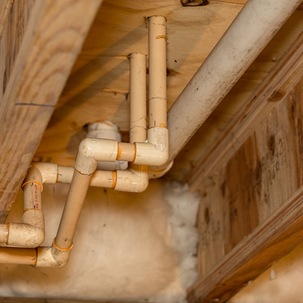 a bunch of pipes are hanging from the ceiling of a building .
