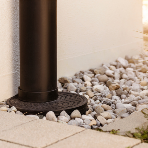 a black pole is sitting on top of a pile of rocks .